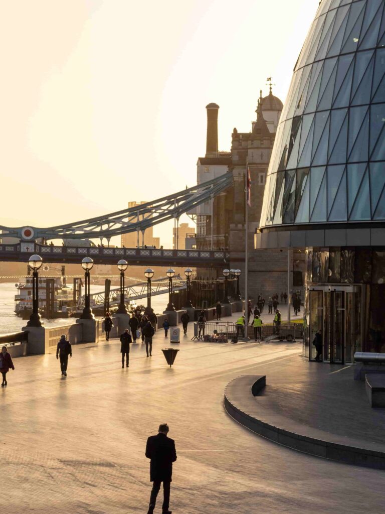 Persone camminano lungo una strada di Londra al tramonto